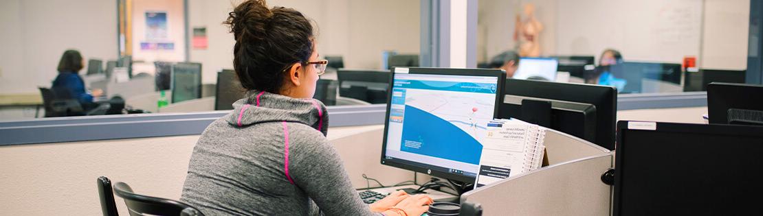 A Student sits in front of a computes